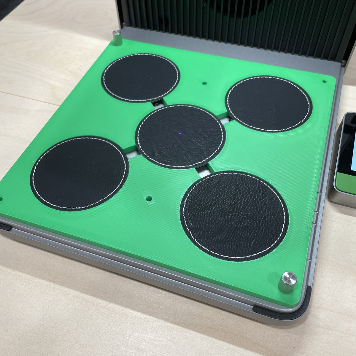 Samcraft green round patch jig in an xTool F1 Ultra laser bed, holding four round dark leatherette patches.