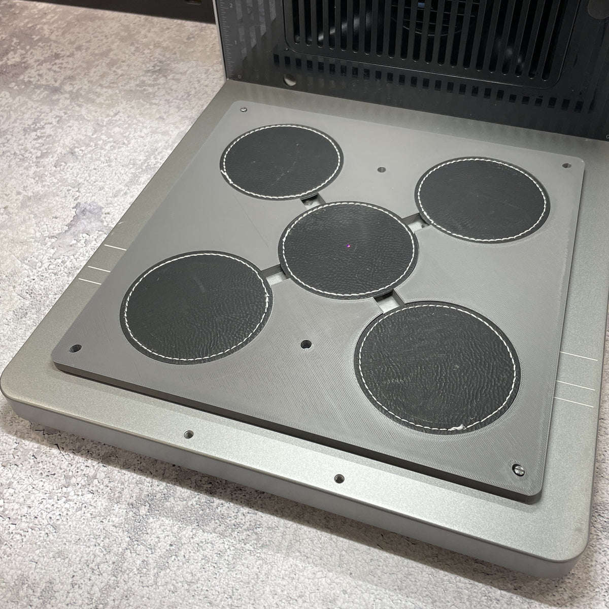 Samcraft round patch jig on the xTool F2 Ultra bed, holding round leatherette patches in two sizes.