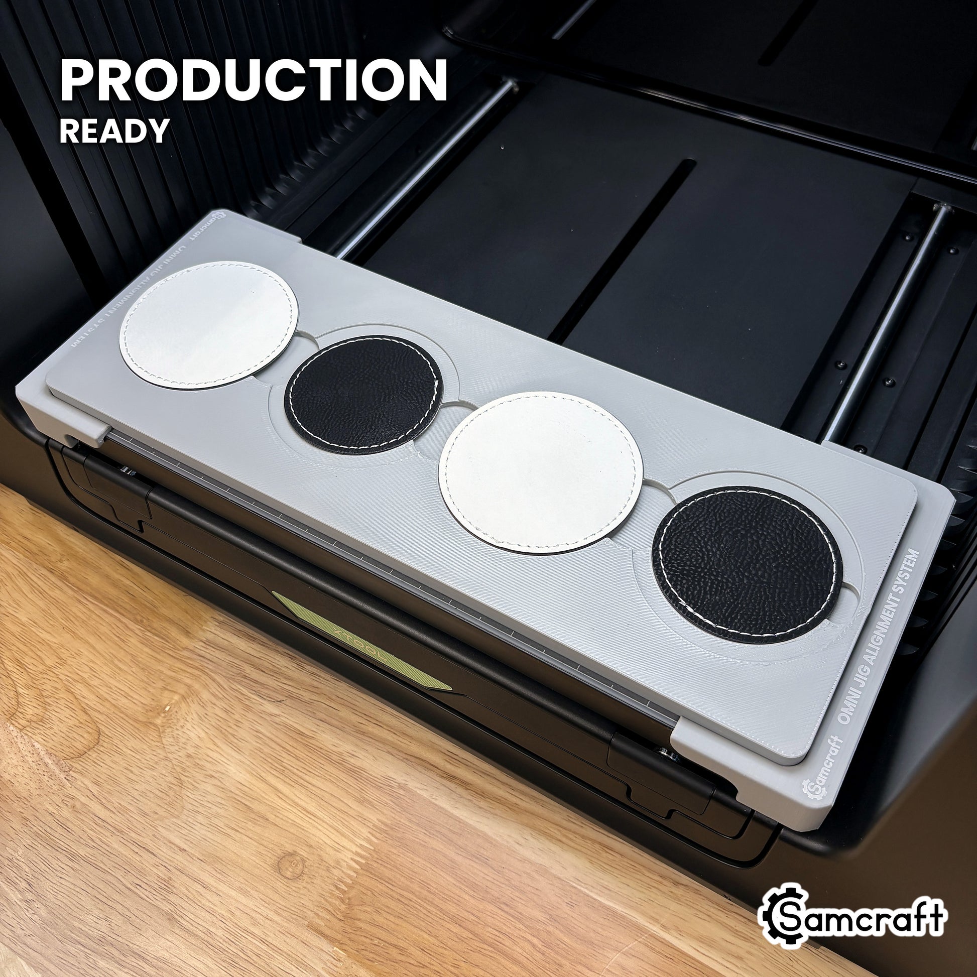 Samcraft round patch jig loaded with four leatherette patches on the xTool Omni UV printer bed, set up for production runs.