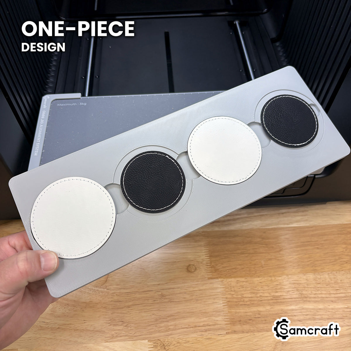 Hand holding the one-piece Samcraft round patch jig for the xTool Omni, four patch pockets in a single molded tray.