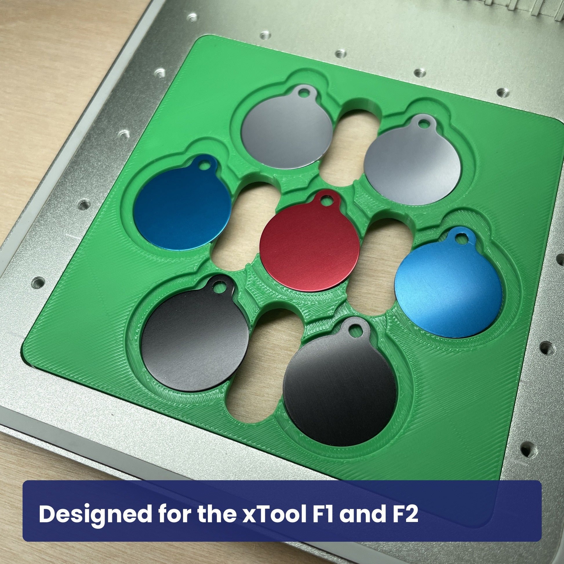Green Samcraft round pet tag jig seated in the xTool F1 base plate with seven coloured round tags in place.