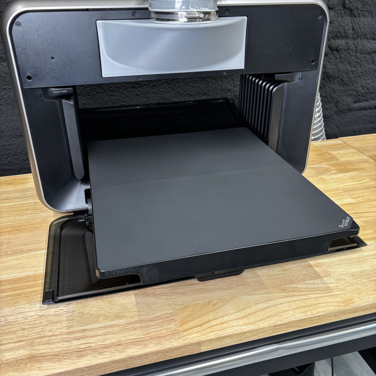 Samcraft FatMat fitted to the print bed of a eufyMake E1 UV printer, the black silicone mat filling the tray.