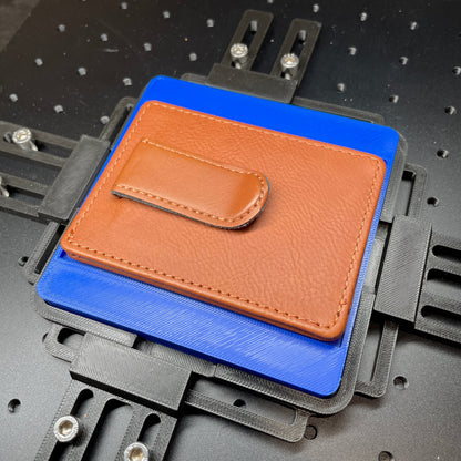 Samcraft blue slim wallet jig on a ComMarker laser bed, holding a tan leather wallet.