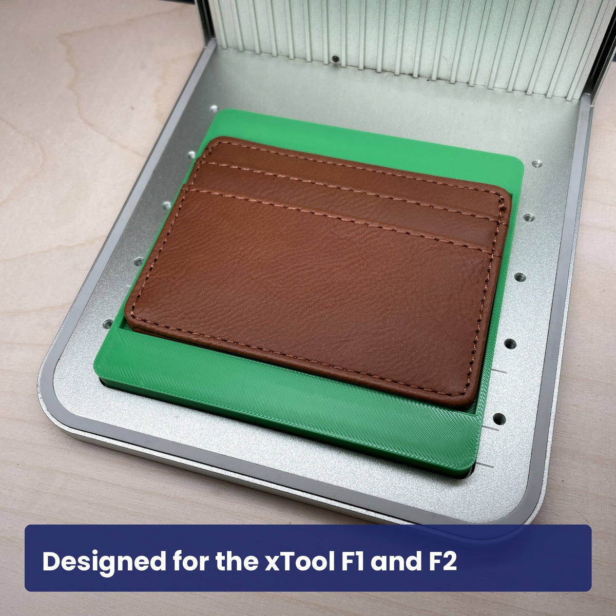 Samcraft slim wallet jig in an xTool F1 laser bed holding a brown leather card holder.