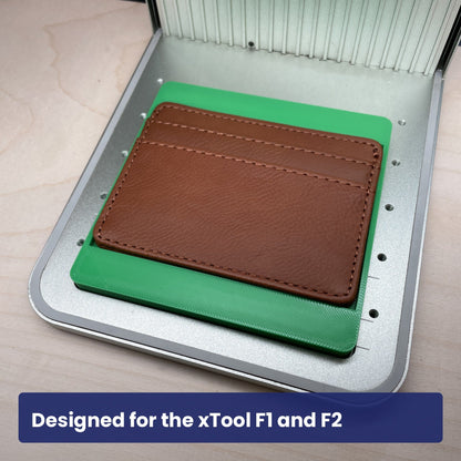 Samcraft slim wallet jig in an xTool F1 laser bed holding a brown leather card holder.
