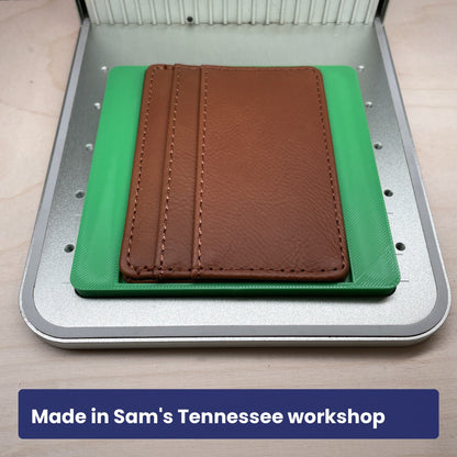 Samcraft slim wallet jig holding a dark brown leather card wallet in the laser bed.