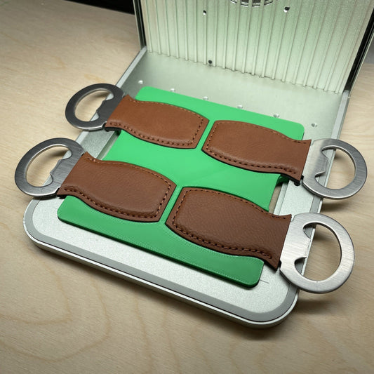 Samcraft small bottle opener jig in an xTool F1 laser bed, holding four brown leather bottle openers.