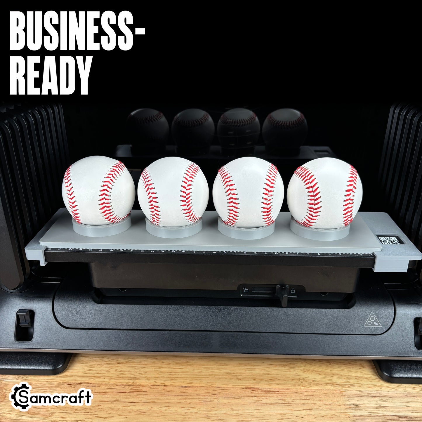 Sports Ball Jig for the eufyMake E1 — front view of the gray 3D-printed tray holding four baseballs in cupped ring holders on the printer bed with built-in alignment ruler, highlighting the business-ready design.