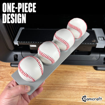 Sports Ball Jig for the eufyMake E1 — hand holding the gray one-piece 3D-printed tray loaded with four baseballs in cupped ring holders, template files included, highlighting the one-piece design.