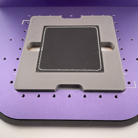 Samcraft square patch jig on the purple bed of a WeCreat Lumos, holding a square black leatherette patch.
