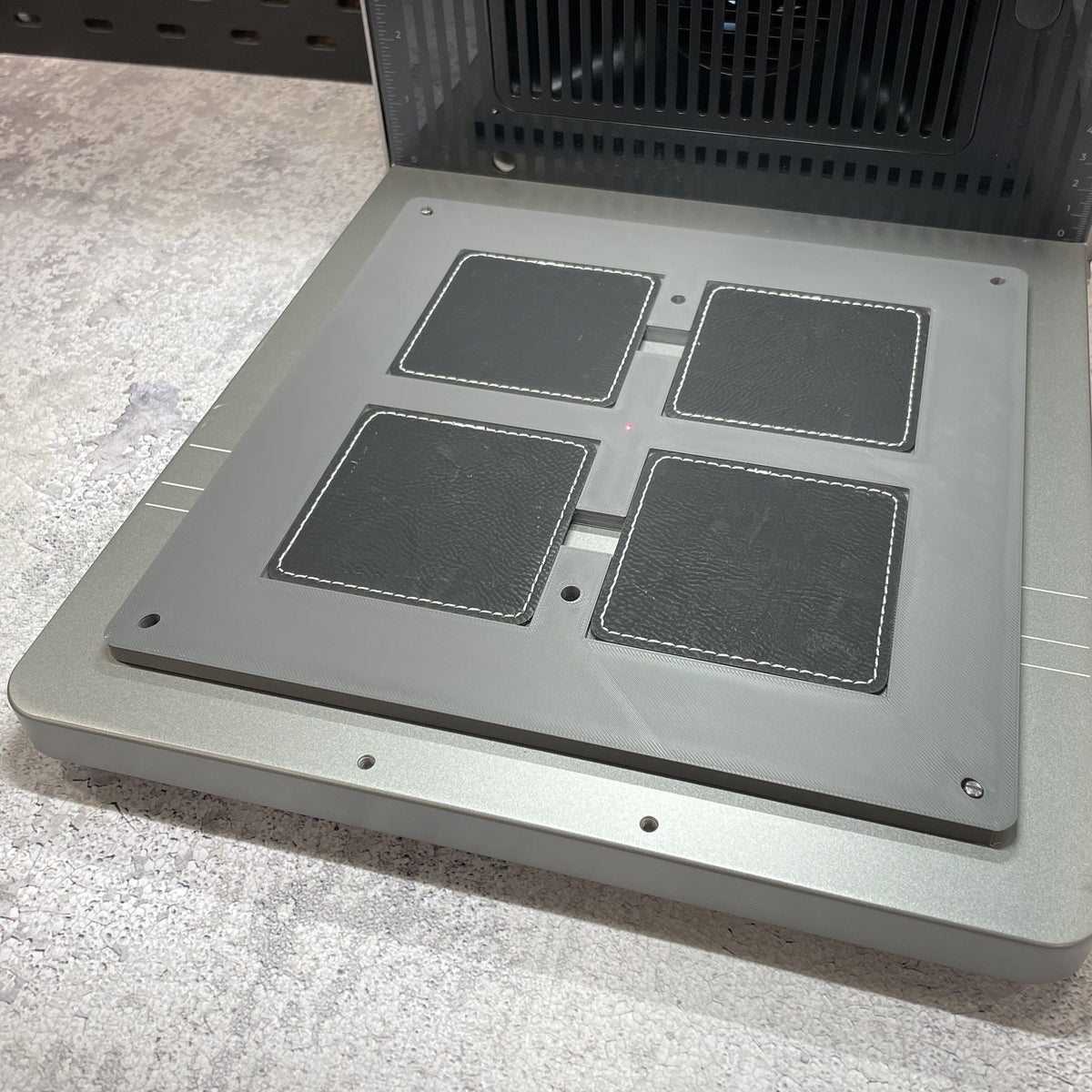 Samcraft square patch jig on the xTool F2 Ultra bed, holding square leatherette patches.
