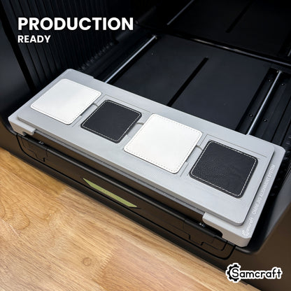 Samcraft square patch jig loaded with four leatherette patches on the xTool Omni UV printer bed, set up for production runs.