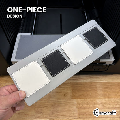 Hand holding the one-piece Samcraft square patch jig for the xTool Omni, four patch pockets in a single molded tray.