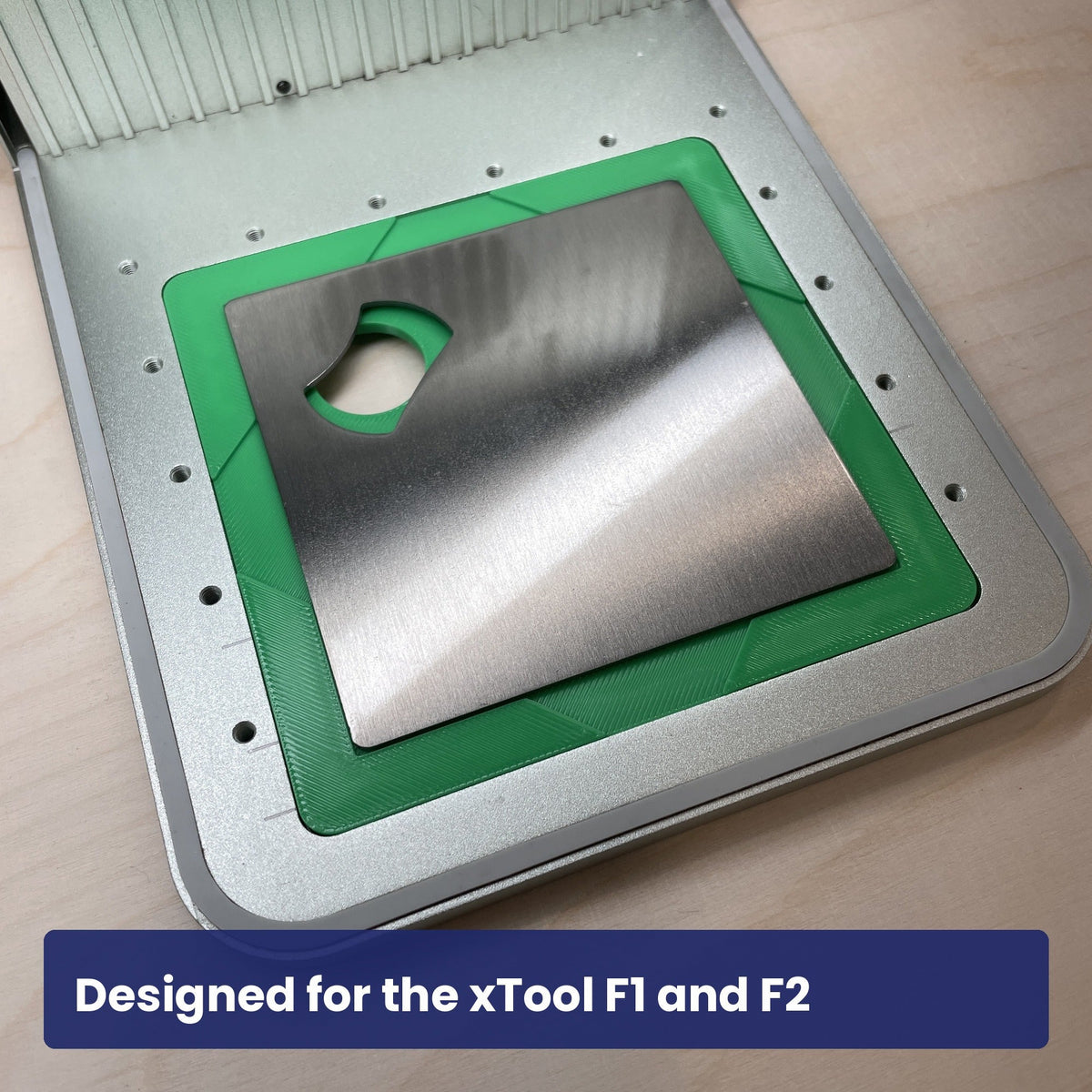 Samcraft stainless bottle opener jig seated in the xTool F1 base plate with an opener in the recess.