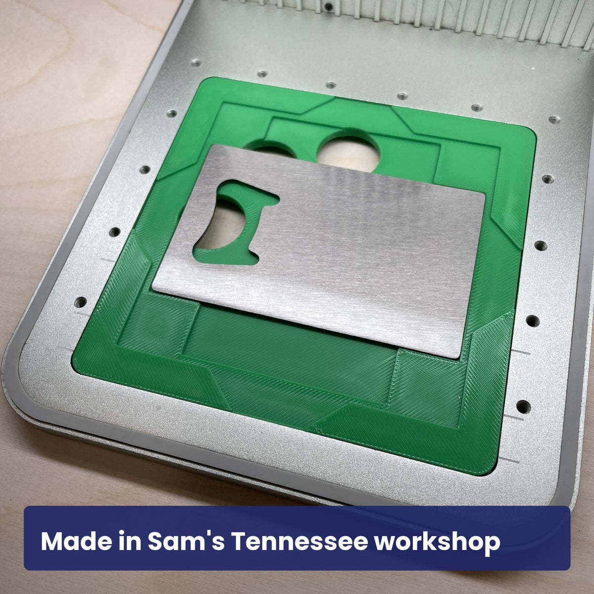 Close view of the Samcraft stainless bottle opener jig in the laser bed.