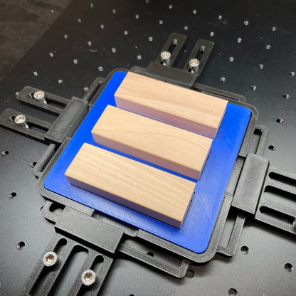Samcraft blue tumbling tower game jig on a ComMarker laser bed, holding wooden game blocks.