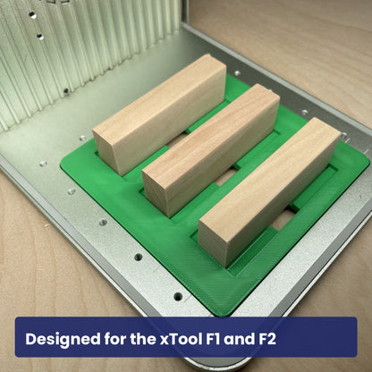 Samcraft tumbling tower jig seated in the xTool F1 base plate with wooden blocks in its channels.