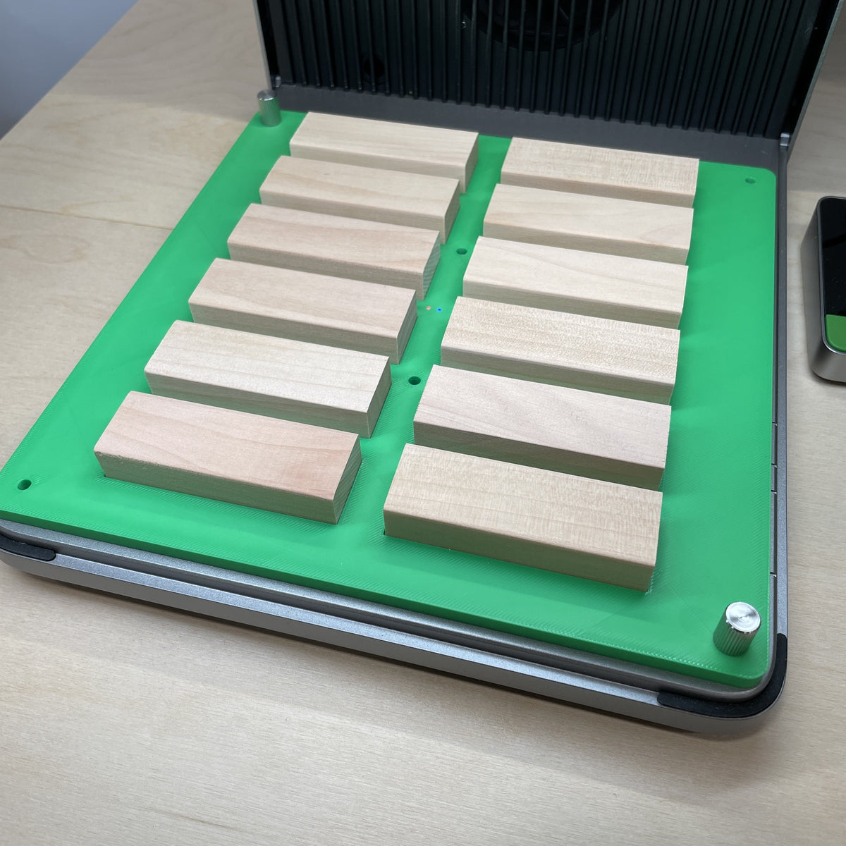 Samcraft green tumbling tower game jig in an xTool F1 Ultra laser bed, holding a full set of wooden game blocks.