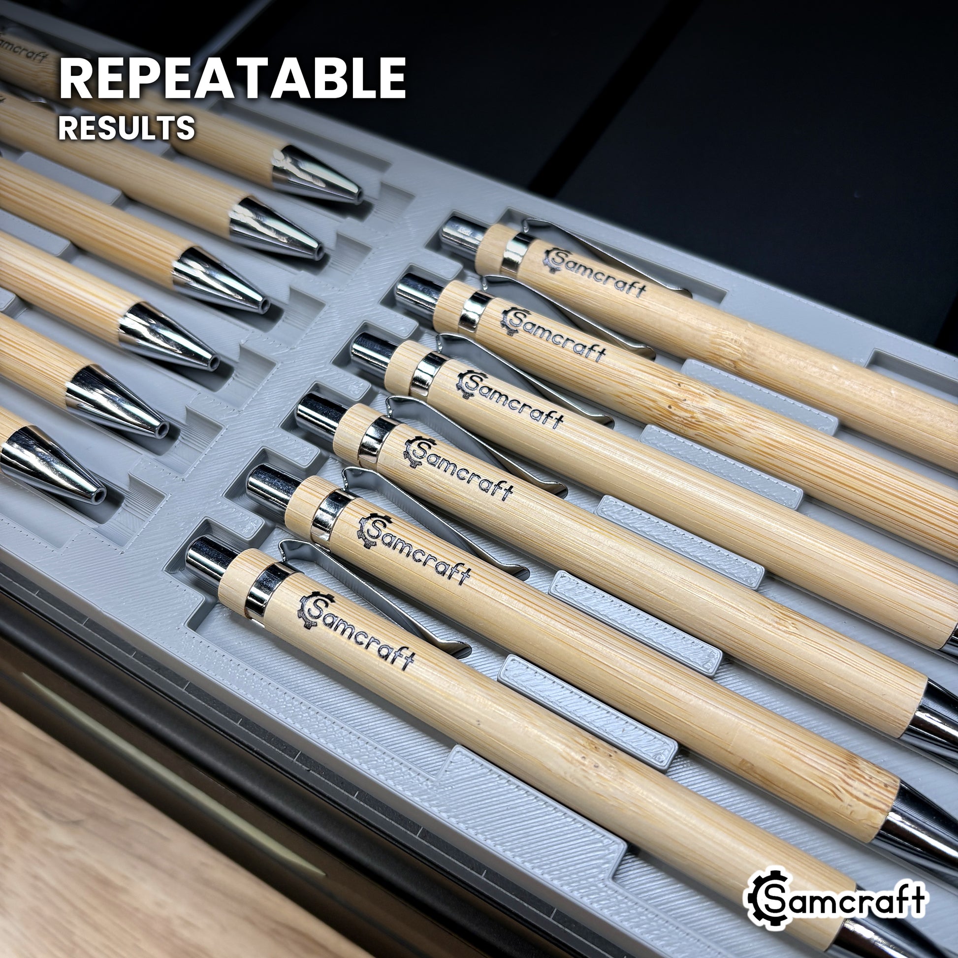 Close-up of printed pens seated in the Samcraft xTool Omni pen jig, the logo landing in the same place on each barrel.