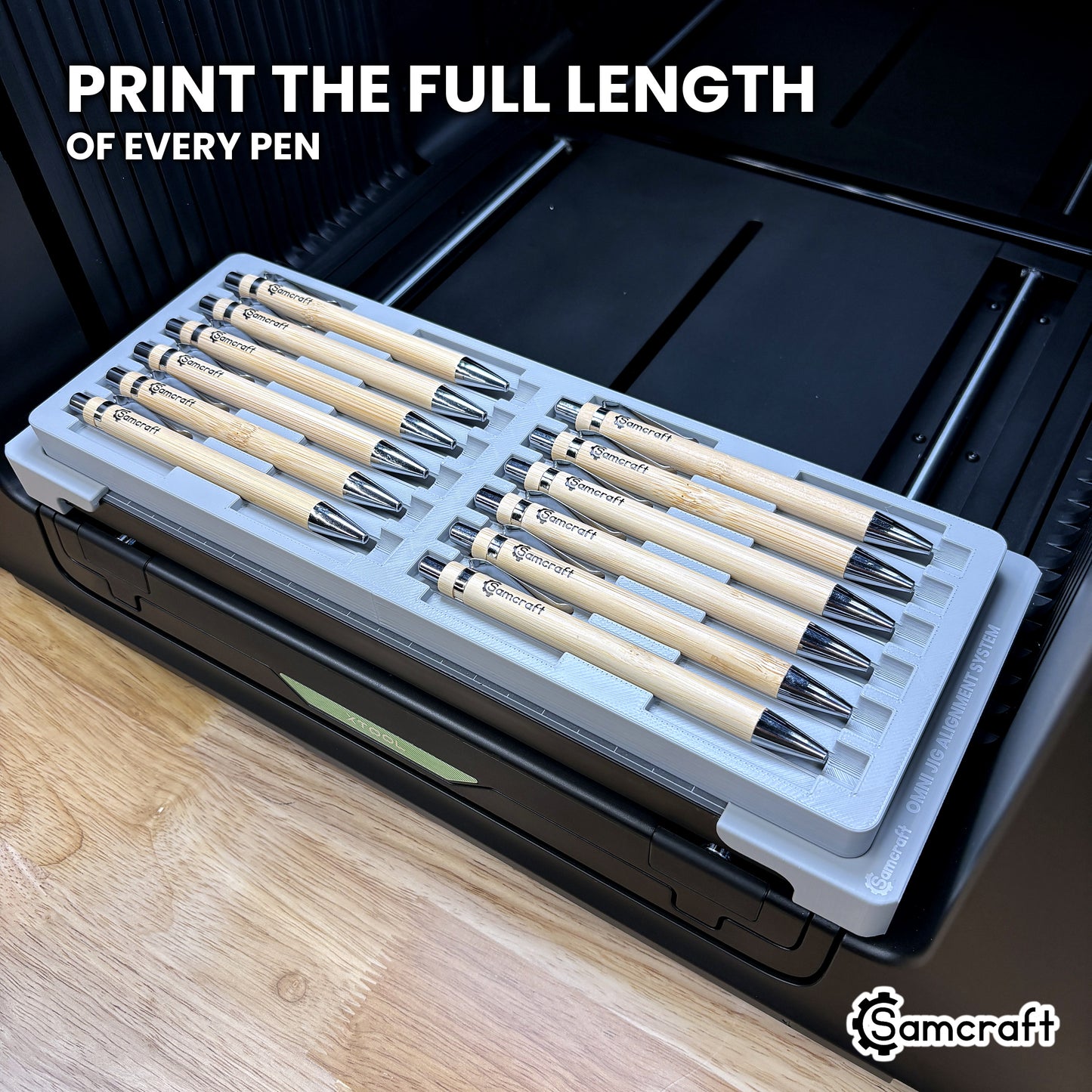 Twelve pens in the Samcraft xTool Omni jig with artwork printed along the full length of every barrel, end to end.
