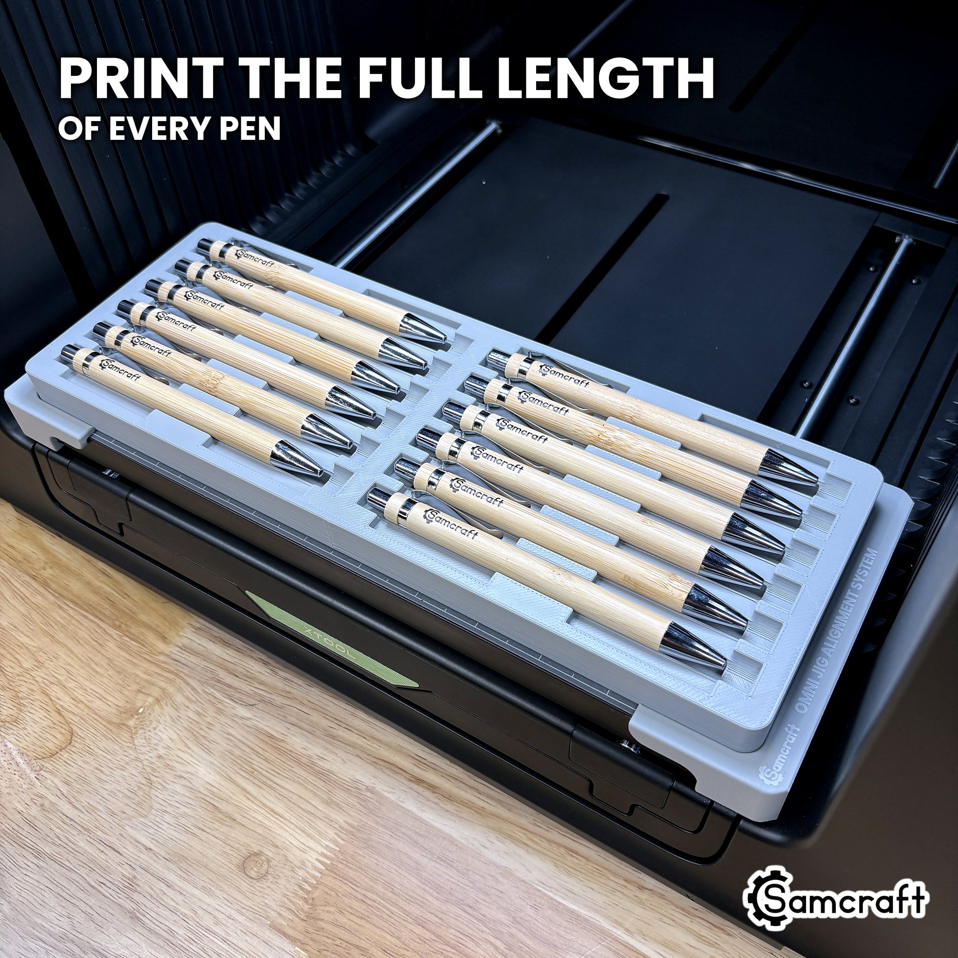 Twelve pens in the Samcraft xTool Omni jig with artwork printed along the full length of every barrel, end to end.