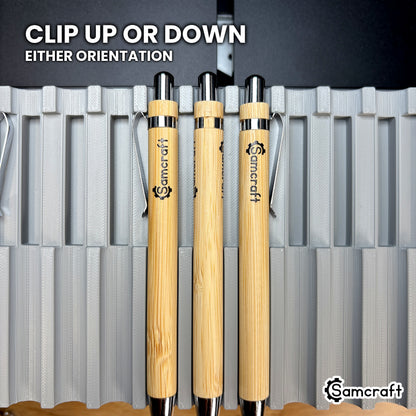 Bamboo pens seated in the Samcraft xTool Omni pen jig with the clips facing up and facing down, showing the jig holds either orientation.