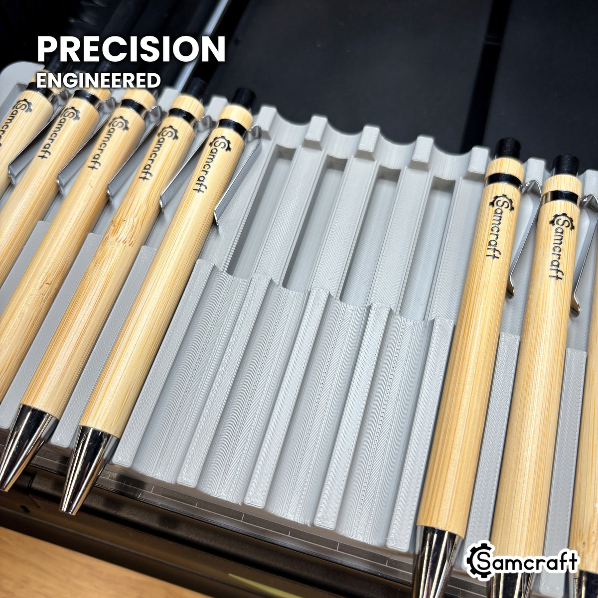 Close-up of the precision-engineered curved cradles in the Samcraft xTool Omni pen jig, with bamboo pens seated beside empty cradles.