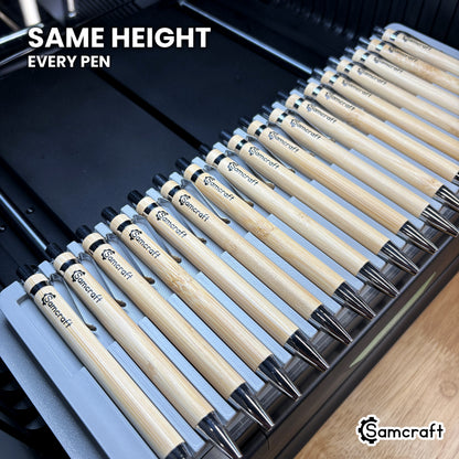Bamboo pen barrels held at matching height across the Samcraft xTool Omni pen jig for consistent print placement on every pen.