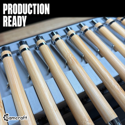 Production-ready Samcraft Universal Pen Jig holding rows of bamboo pens with chrome tips in recessed channels on the eufyMake E1 UV printer bed.