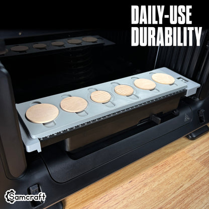 Wood Coin Jig for the eufyMake E1 — gray 3D-printed tray full of round wooden coins on the printer bed with built-in alignment ruler, highlighting daily-use durability.