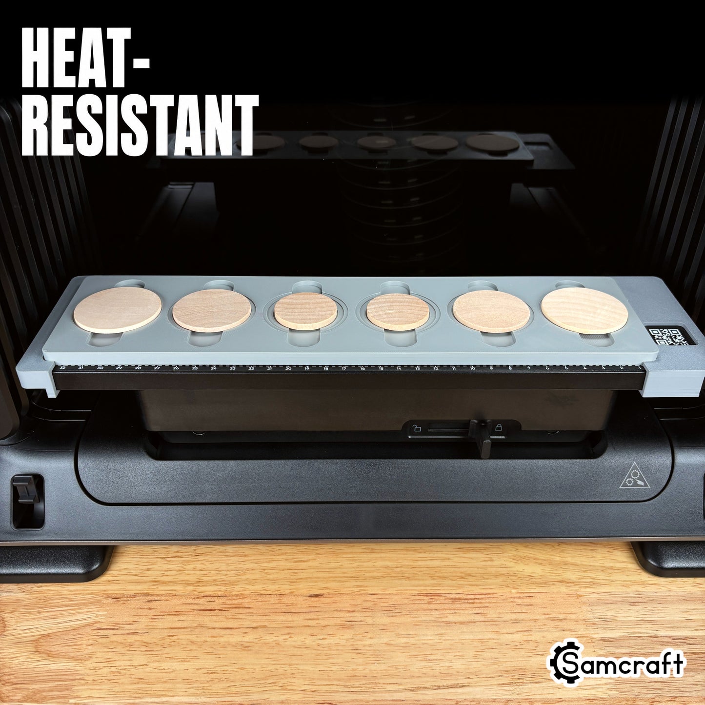 Wood Coin Jig for the eufyMake E1 — front view of the gray 3D-printed tray holding six round wooden coins seated on the printer bed with built-in alignment ruler, highlighting the heat-resistant material.