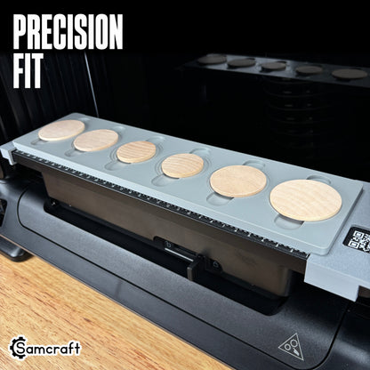 Wood Coin Jig for the eufyMake E1 — angled view of the gray one-piece 3D-printed tray seated on the printer bed with six wooden coins and the built-in alignment ruler, highlighting the precision fit.