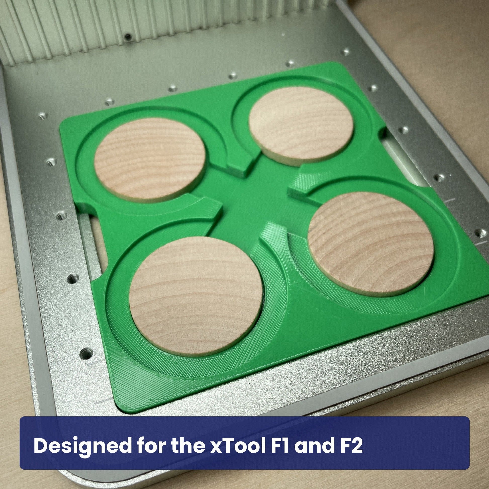 Samcraft wood coin jig seated in the xTool F1 base plate with four wooden coins in place.