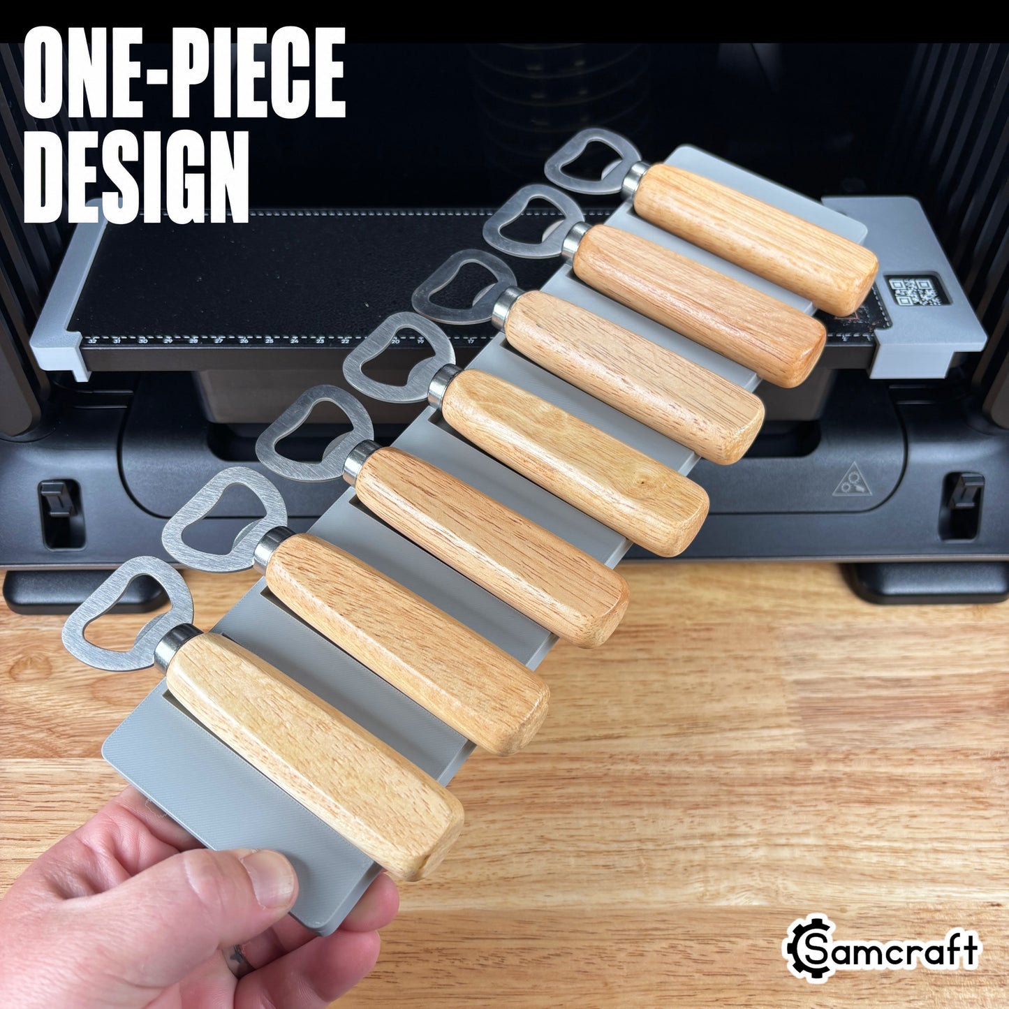 Wood Handle Bottle Opener Jig for the eufyMake E1 — hand holding the gray one-piece 3D-printed tray loaded with wood-handle bottle openers, template files included, highlighting the one-piece design.