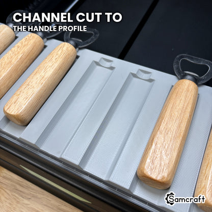 Close-up of the empty channels in the Samcraft xTool Omni opener jig, each cut to the wood handle's profile.