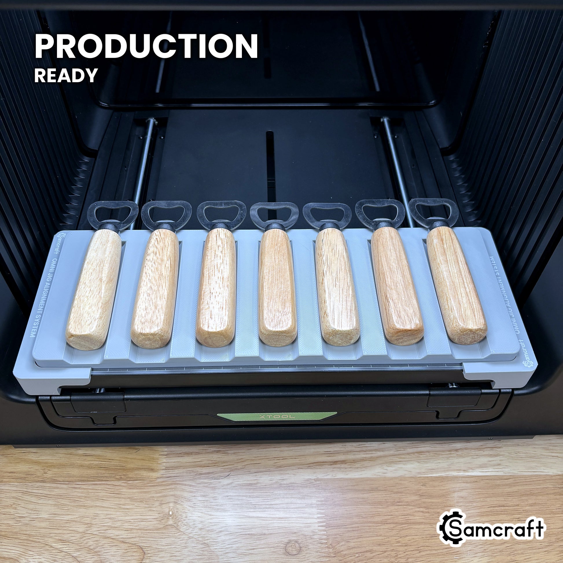 Samcraft wood handle opener jig loaded with seven openers on the xTool Omni UV printer bed, set up for production runs.