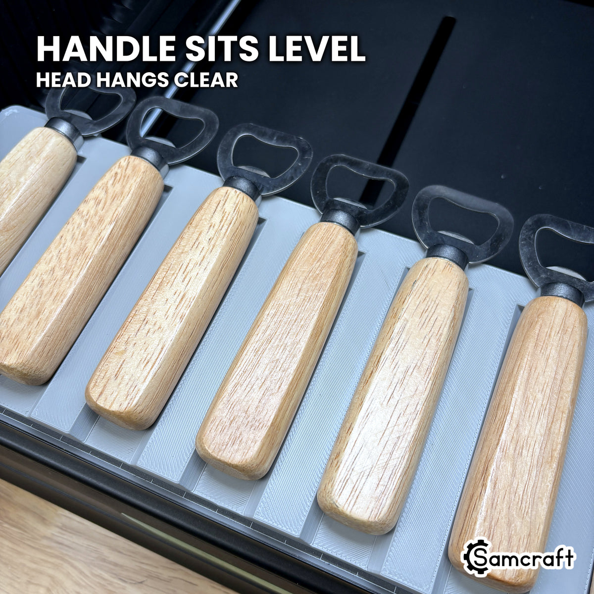 Wood handles sitting level in the Samcraft xTool Omni jig with the steel heads hanging clear of the plate.