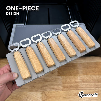 Hand holding the one-piece Samcraft wood handle bottle opener jig for the xTool Omni, seven openers seated in a single molded tray.