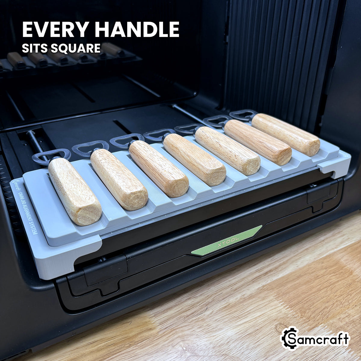 Every wood handle seated square in its own channel across the Samcraft xTool Omni jig, for consistent print placement.