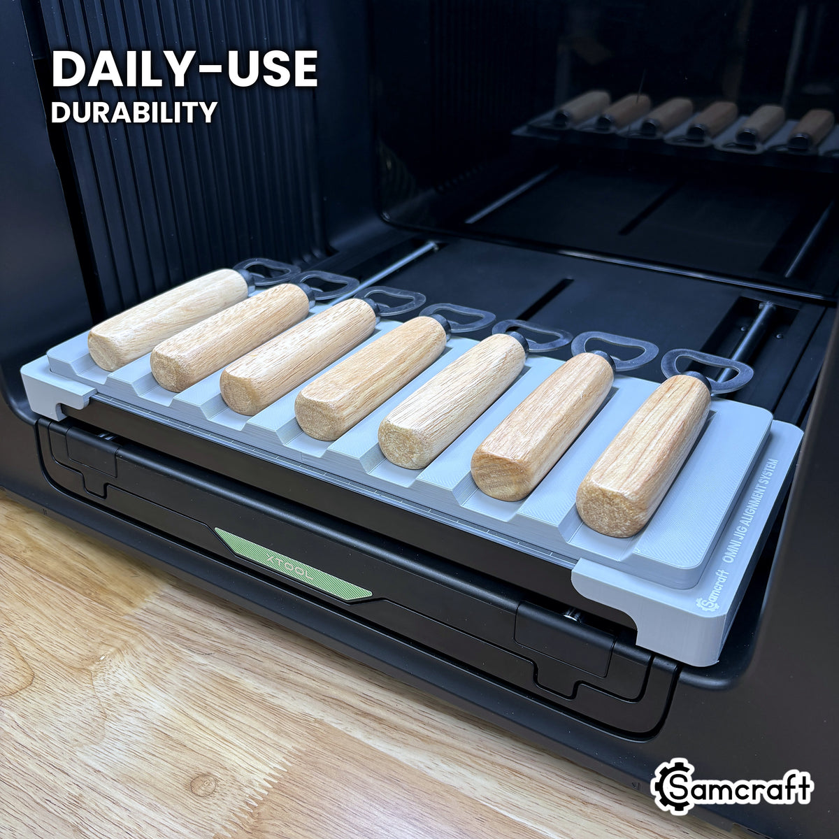 Samcraft wood handle opener jig in high-temperature rated plastic holding seven openers on the xTool Omni bed, built for daily-use durability.